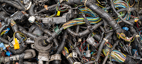 Tangled pile of discarded automotive wiring harnesses.